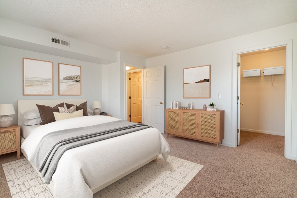 A bedroom with a large bed and a wooden cabinet.