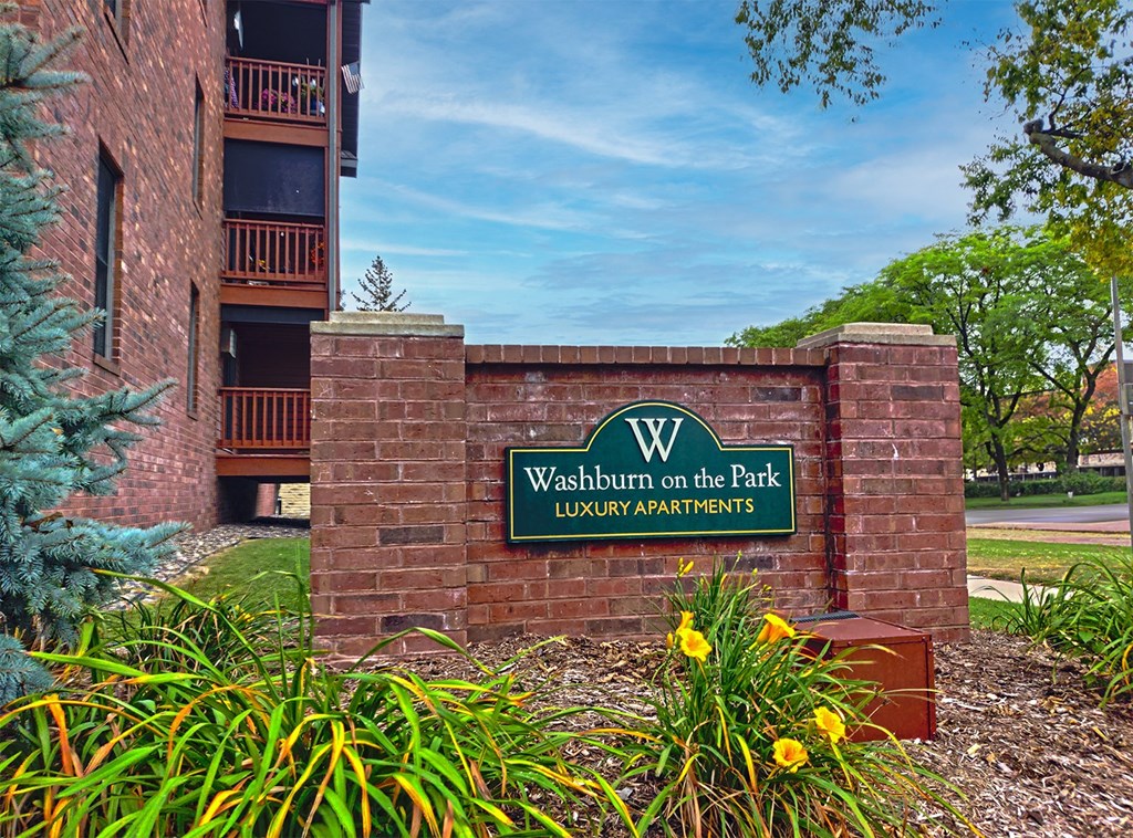 a brick wall with a sign that reads welshburn on the park luxury apartments