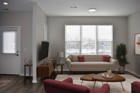 A living room with a red couch and a television.