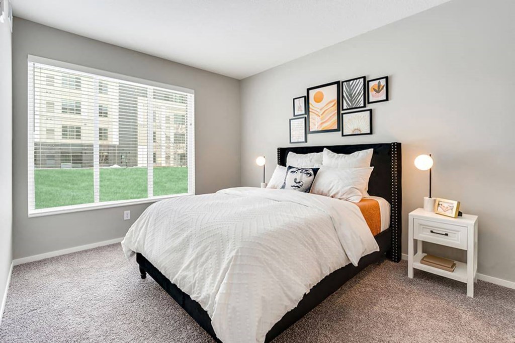 a bedroom with a large window and a bed