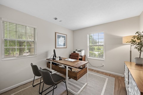 A room with a desk and chairs.