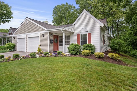 A house with a red door and white garage doors.