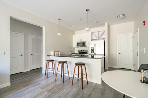 A kitchen with a bar stool and a counter.