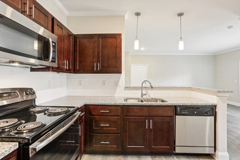 A kitchen with dark wood cabinets and stainless steel appliances.