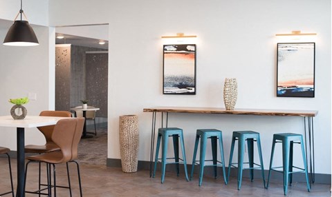 A dining area with a table, chairs, and two framed pictures on the wall.