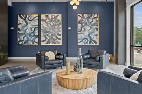 A living room with a large painting on the wall and a wooden coffee table in the center.