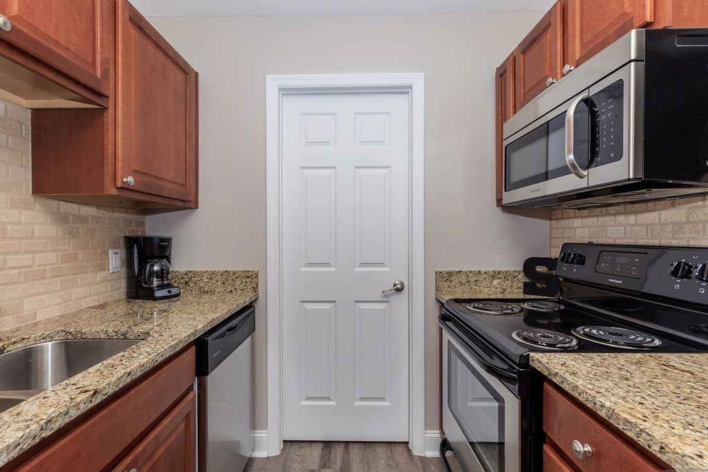 a kitchen with granite counter tops and a white door a kitchen with granite counter tops and a white door at Sawgrass Apartments, South Carolina, 29412