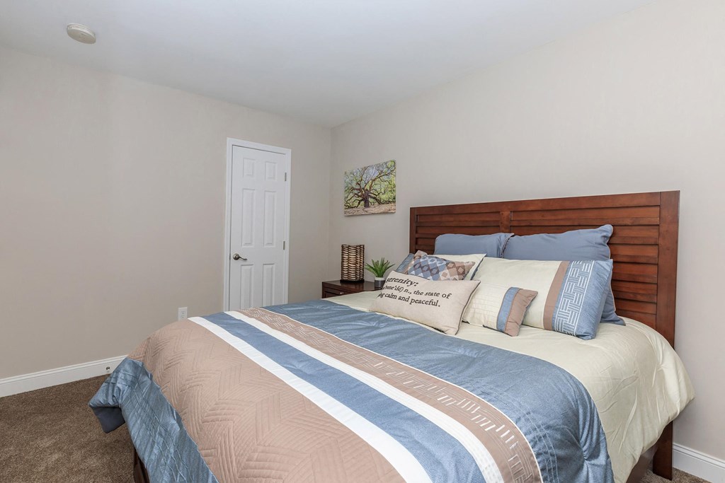 a bedroom with a bed and a white door a bedroom with a bed and a white door at Sawgrass Apartments, Charleston, SC