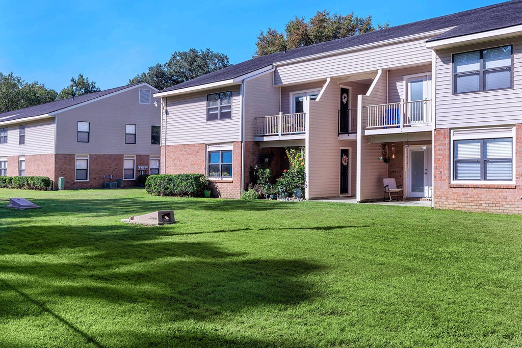 an apartment building with green grass in front of it an apartment building with green grass in front of it at Sawgrass Apartments, Charleston