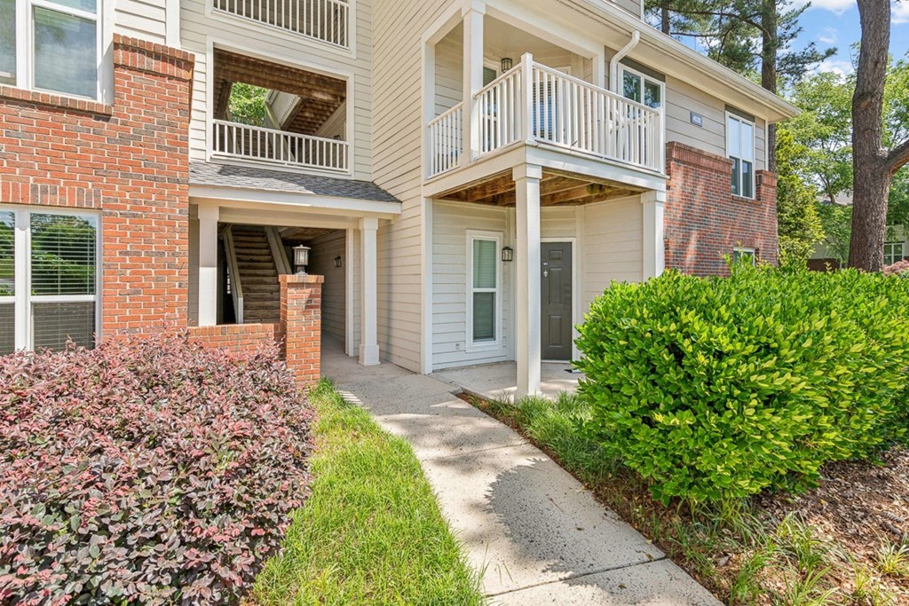 the pathway to the front entrance of an apartment building with a porch at The Falls Apartments in Raleigh NC