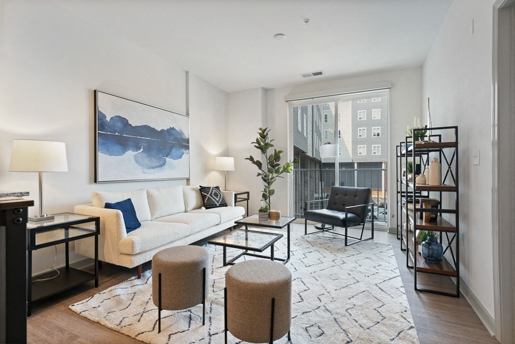 a living room with a white couch and a large blue and white painting on the wall at The Constellation Apartments, PRG Real Estate, Hampton, Virginia