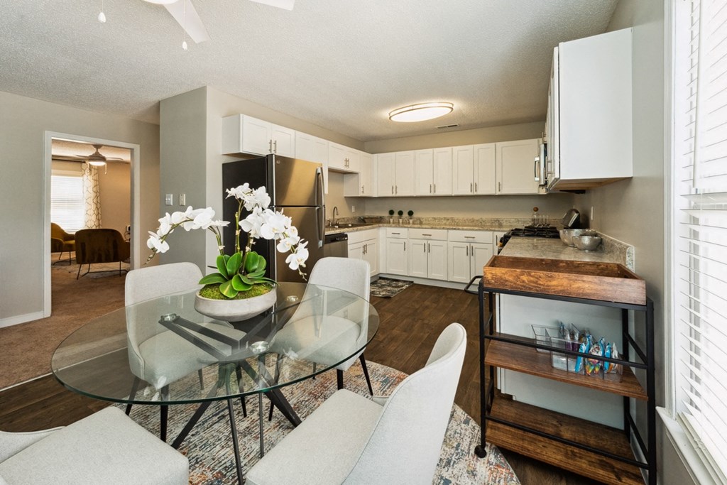 a kitchen and dining room with white cabinets and a glass table at Hyde Park Townhomes, PRG Real Estate Management, Chester, VA