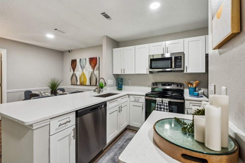 A modern kitchen with white cabinets and stainless steel appliances.at Chapel View, North Carolina