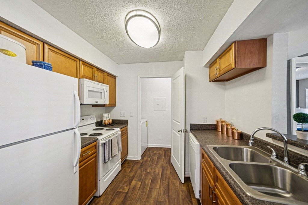 A kitchen with a white fridge and wooden cabinets at Willow Ridge Apartments, North Carolina, 28210