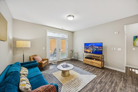 A living room with a blue couch and a television.