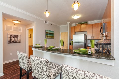 a kitchen with a bar and a counter top with chairs