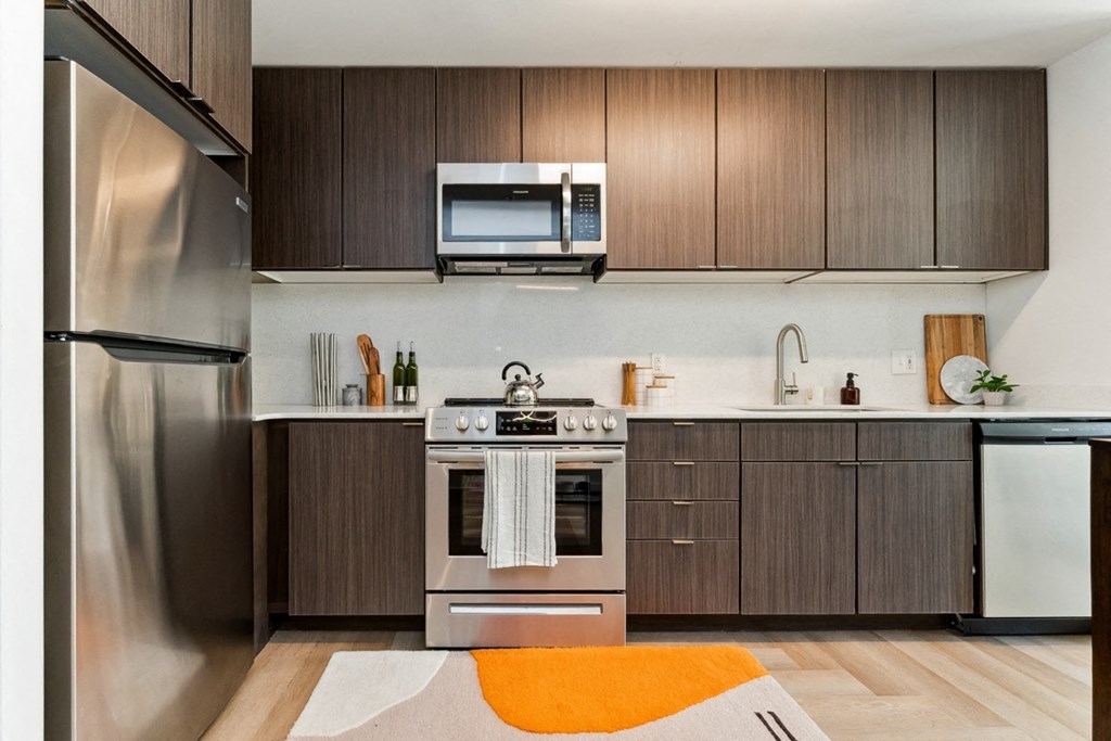 a kitchen with dark wood cabinets and an orange rug at Hydro, Richmond, Virginia