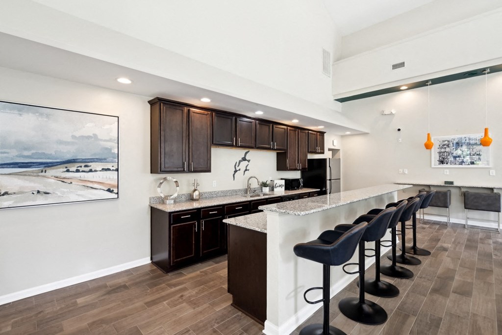 a kitchen with a bar and stools in a house at The Falls Apartments in Raleigh NC