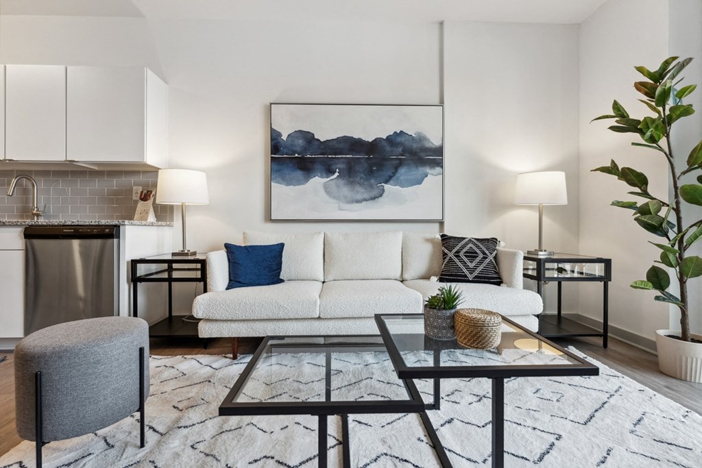 a living room with a couch coffee table and a kitchen in the background at The Constellation Apartments, PRG Real Estate, Hampton, Virginia