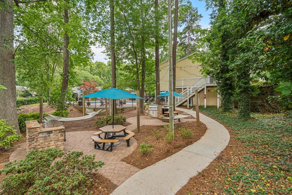 a picnic area with benches and umbrellas in a park