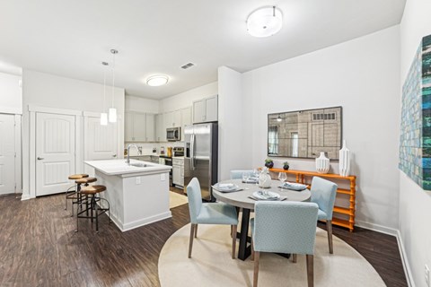 A kitchen with a dining table and chairs.