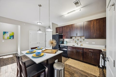 A modern kitchen with dark wood cabinets and a white island.