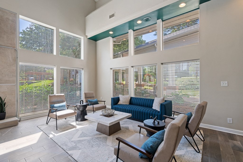 a seating area with a row of chairs and a wall of windows at The Falls Apartments in Raleigh NC