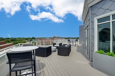 a balcony with tables and chairs and a view of the city at The Constellation Apartments, PRG Real Estate, Hampton, Virginia