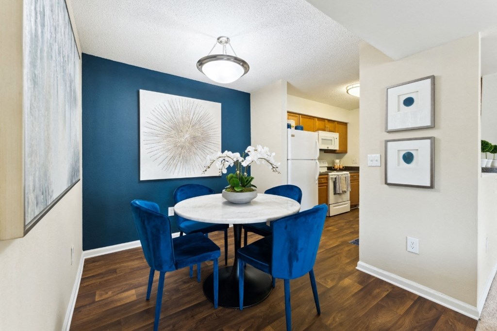 a dining area with a table and chairs and a kitchen in the background  at Willow Ridge Apartments, Charlotte
