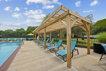 a row of blue lounge chairs next to a swimming pool at The Grove at Lyndon, Louisville