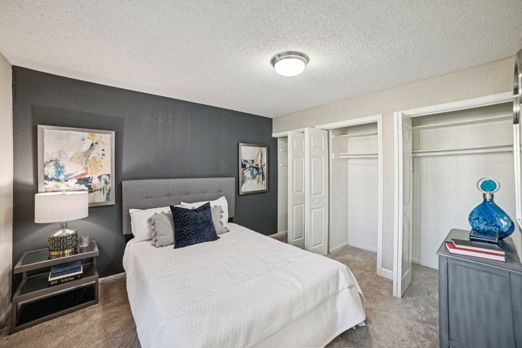A bedroom with a large bed and a painting on the wall at Willow Ridge Apartments, North Carolina, 28210