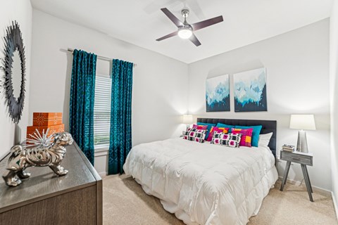A bedroom with a white bed and a ceiling fan at Proximity Apartments, South Carolina, 29414