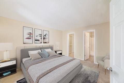 A bedroom with a large bed and a chair in the doorway.