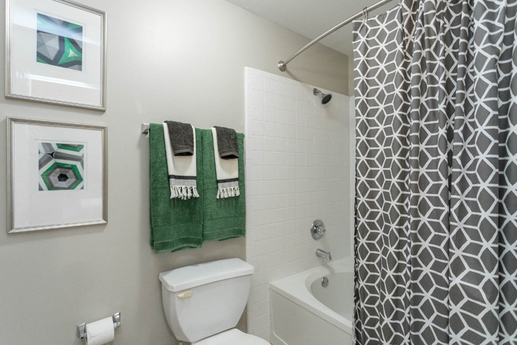 a bathroom with a white toilet next to a bathtub at The Resort At Lake Crossing Apartments, PRG Real Estate, Lexington, KY