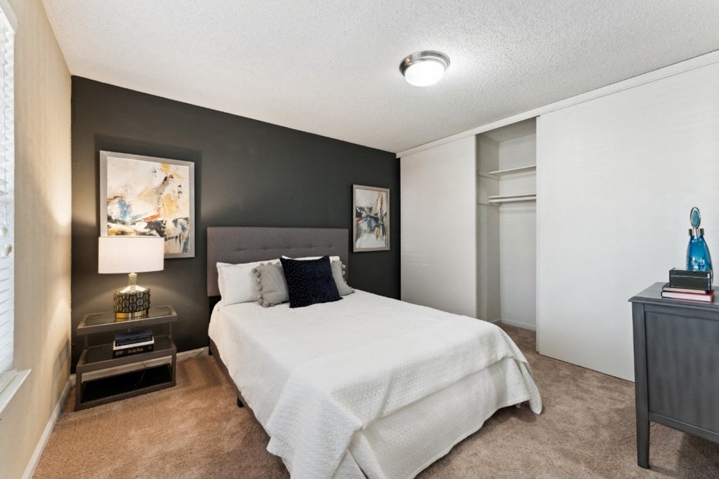 a bedroom with a bed and a nightstand  at Willow Ridge Apartments, Charlotte