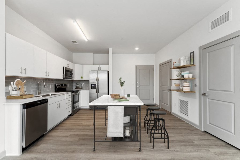 a kitchen with white cabinetry and a large white island with a white countertop