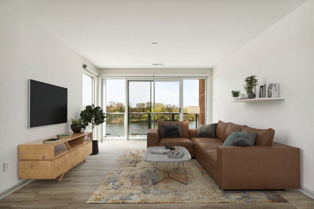 a living room with a large brown couch and a flat screen tv on the wall