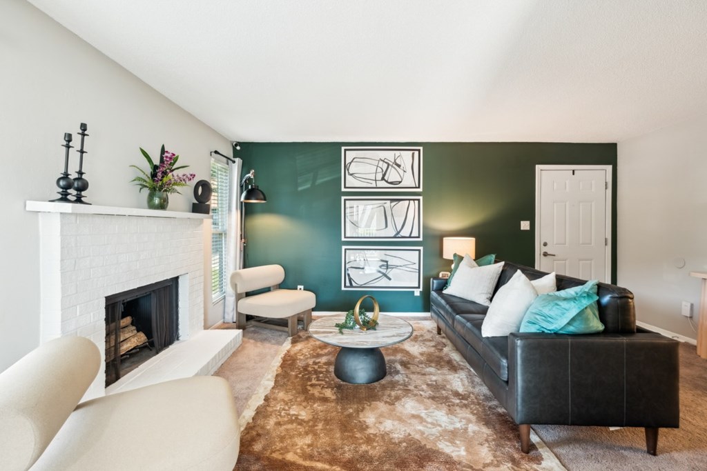 A living room with a fireplace, a couch, and a rug. at Woodcreek Apartments, Cary 27511