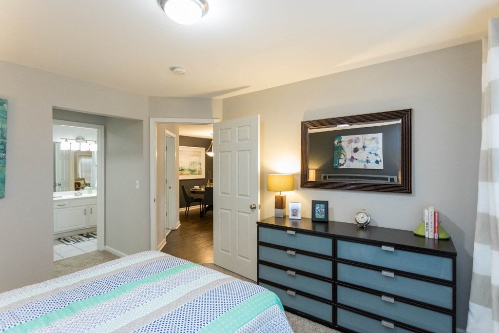 a bedroom with a bed and a dresser at The Resort At Lake Crossing Apartments, PRG Real Estate, Lexington, KY