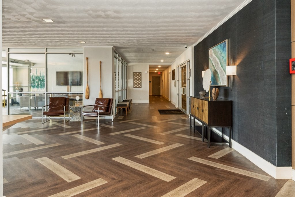 a lobby with chairs and a table and a hallway with wood floors at The Lafayette Apartments, Colonial Place, Norfolk