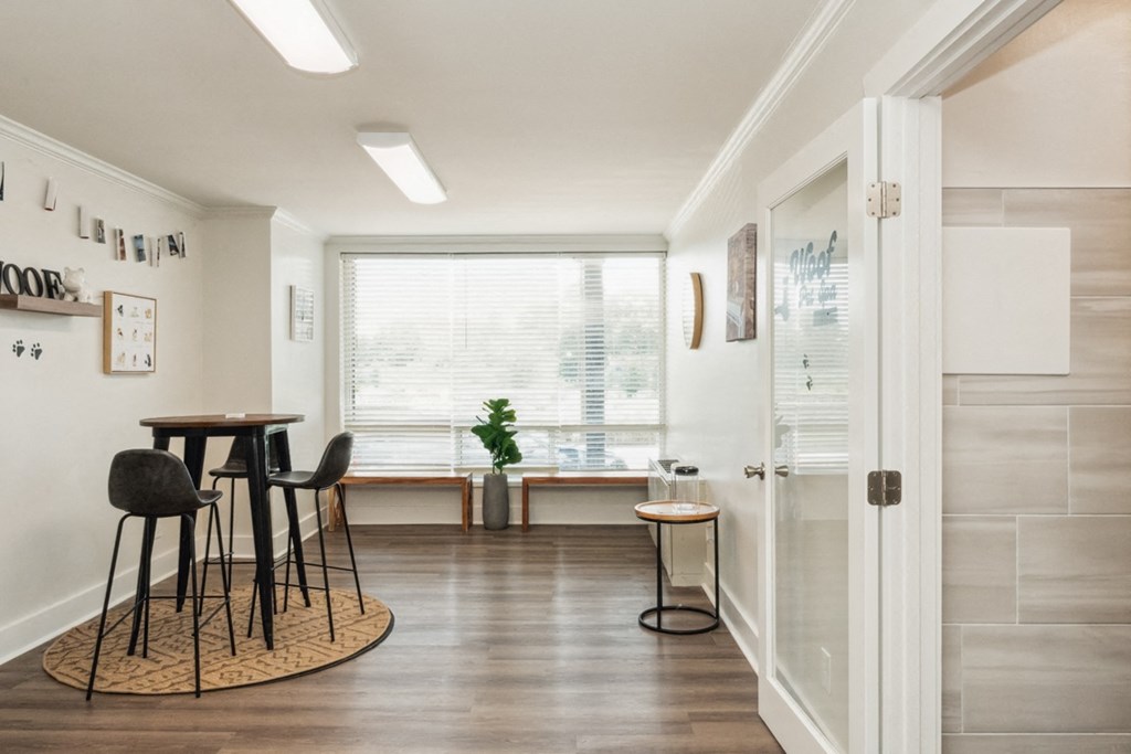 a dining room with a table and chairs and a window at The Lafayette Apartments, Colonial Place, Norfolk