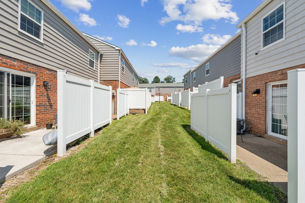 A row of houses with white fences in front at Staples Mill Townhomes Apartments, Richmond, VA