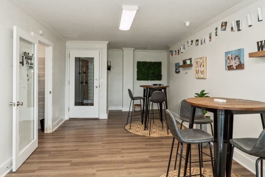 a dining area with a table and chairs and a door to a hallway at The Lafayette Apartments, Colonial Place, Norfolk