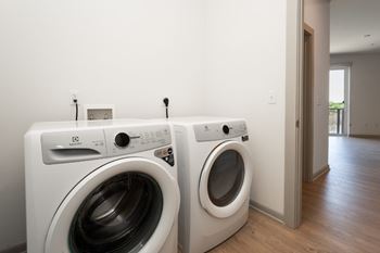 Two white front load washing machines in a laundry room.