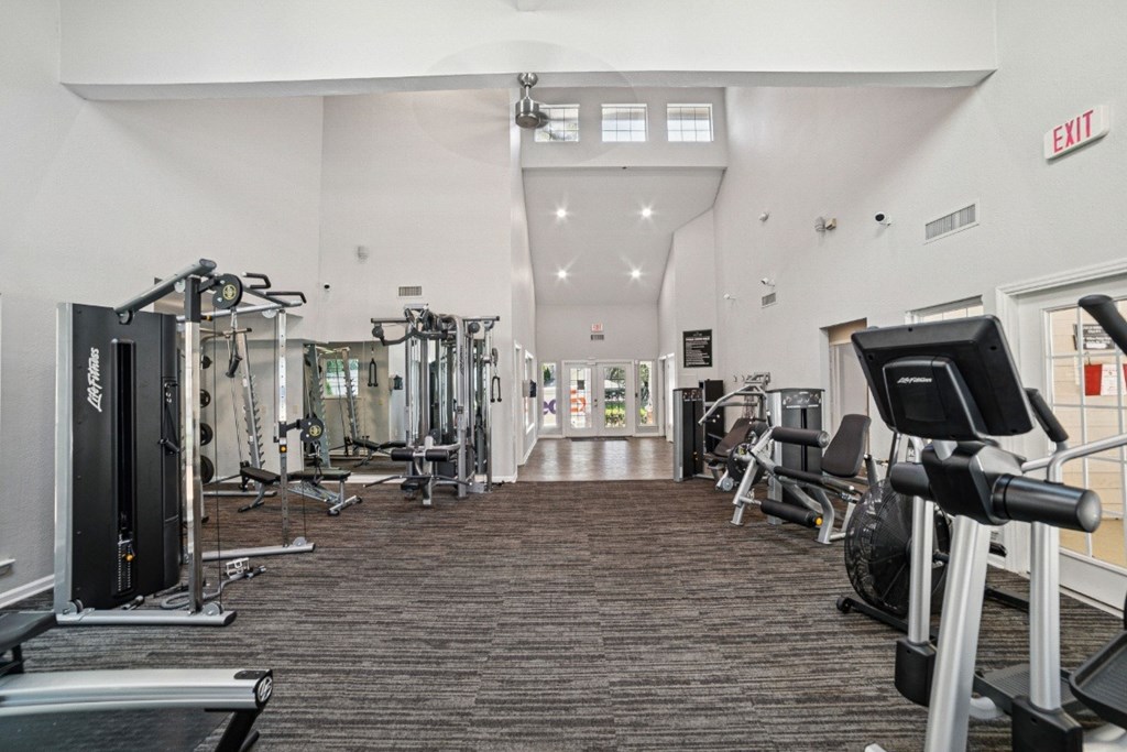 A gym with a variety of equipment including treadmills, weights, and exercise machines at Willow Ridge Apartments, North Carolina, 28210