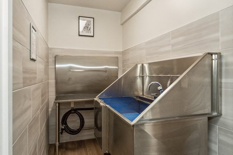 a stainless steel kitchen with a sink and a bar in a small room