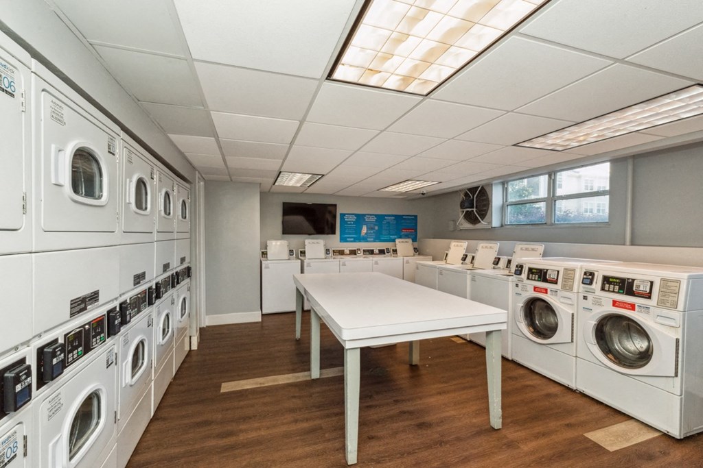 a washer and dryer laundry room with tables and washing machines at The Lafayette Apartments, Colonial Place, Norfolk