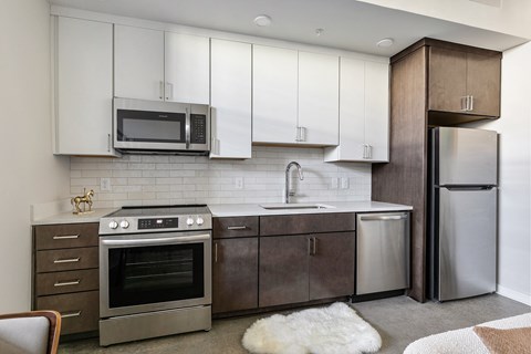 A modern kitchen with a stainless steel refrigerator and oven.