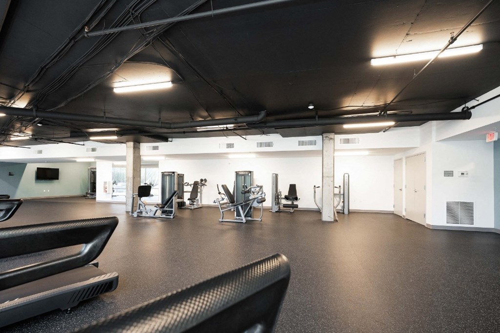 a gym with treadmills and other exercise equipment in an empty room