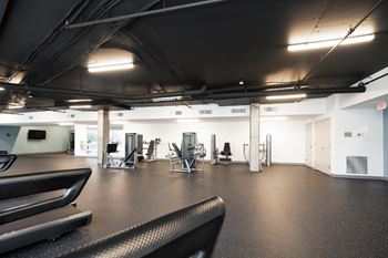 A gym with treadmills, weights, and exercise machines.